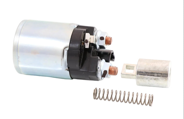Advance Truck Parts USA 028099-9701 Denso starter solenoid showing a clean studio view of the solenoid body, plunger, spring, and terminal studs on a plain white background