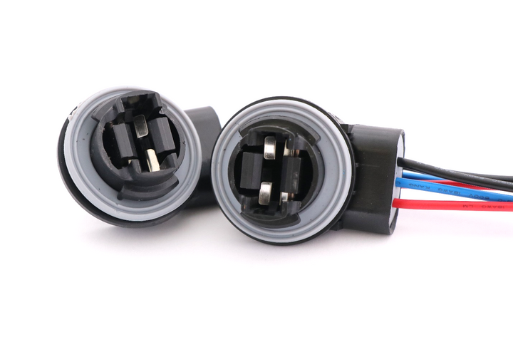 Advance Truck Parts USA 3157 4157 bulb socket brake turn signal light harness showing a clean studio view of the dual sockets, rubber O-rings, and terminal contacts on a plain white background