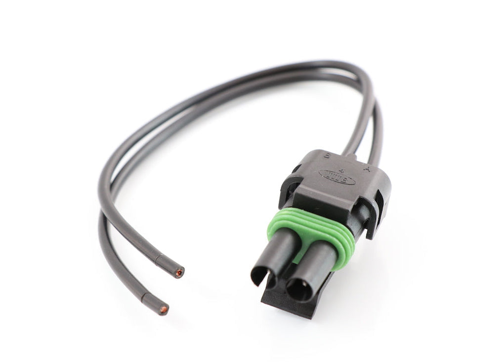 Advance Truck Parts USA W094116 2-pin pigtail connector showing a clean studio view of the black weather-pack housing, green seal, and wire leads 