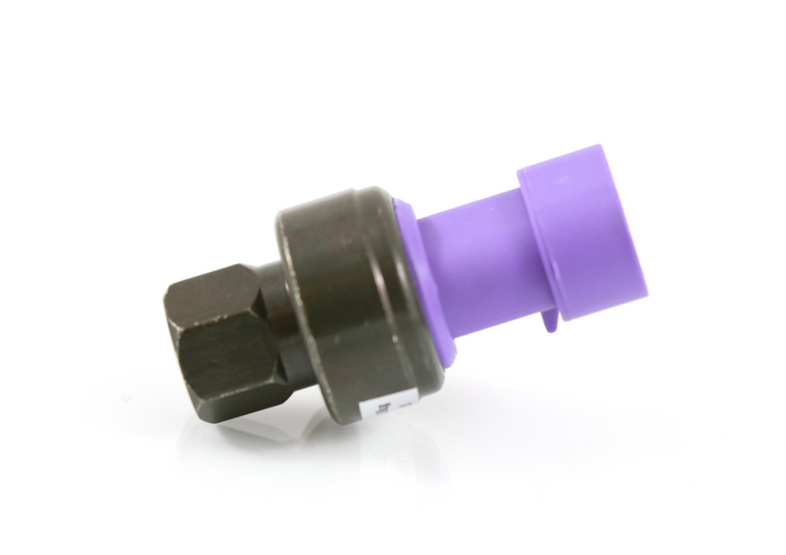 Advance Truck Parts 18-03835 high pressure switch for Peterbilt trucks showing an angled studio view of the female M10-1.25 threaded brass fitting and purple electrical connector on a plain white background