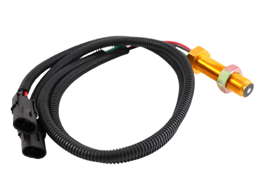 Advance Truck Parts USA N14 engine speed sensor showing an angled profile of the gold-toned 3/4-16 threaded body, securing hex nut, coiled black protective wire loom, and dual black electrical connectors on a plain white background