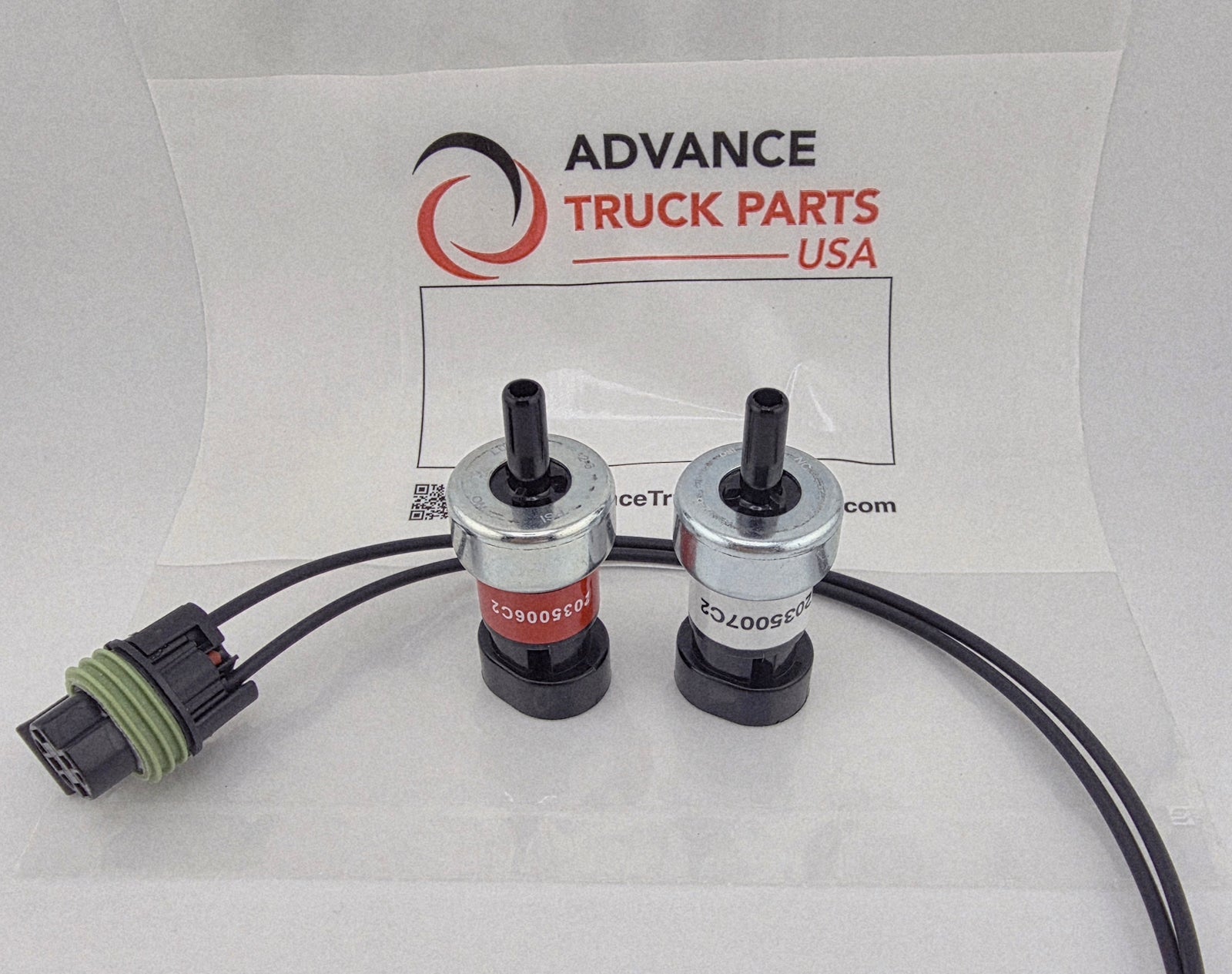 Advance Truck Parts USA 2035006C2 and 2035007C2 air brake switch set for Navistar International showing a studio view of the two pressure switches and connected pigtail harness on a branded packaging background