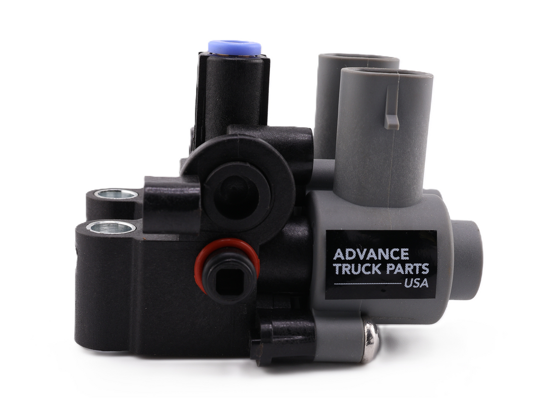 Advance Truck Parts USA W072045 ABS solenoid valve showing a side profile of the black and grey plastic housing with a printed logo, vertical grey electrical connectors, and air ports featuring red and blue seals on a plain white background