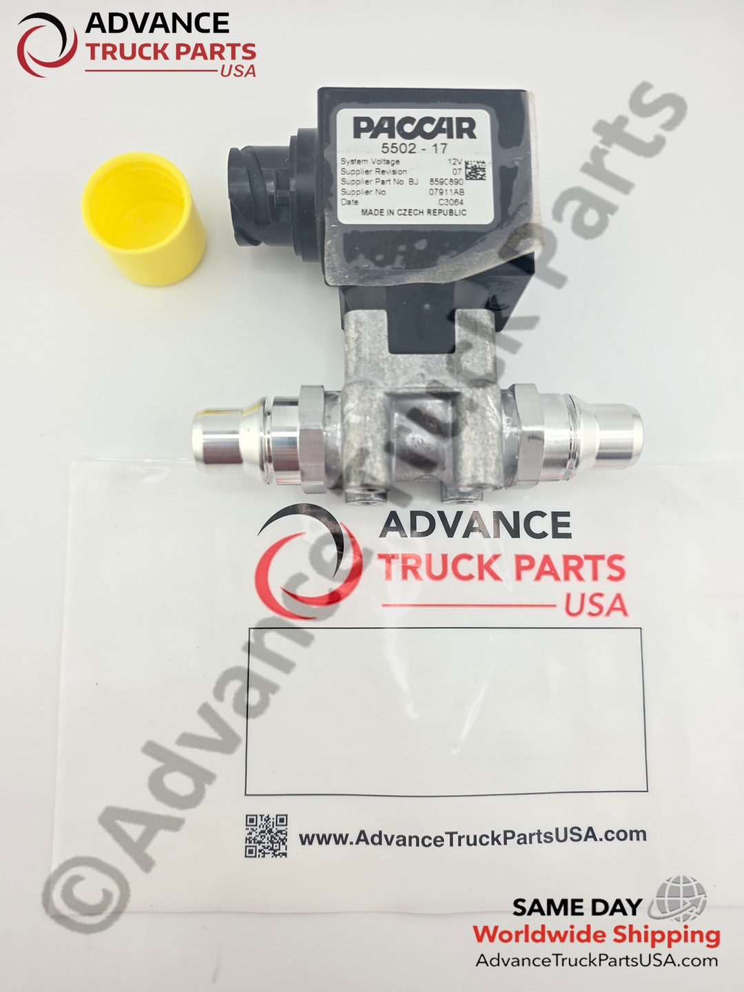 Advance Truck Parts USA branded studio overhead perspective showing the Genuine Paccar DEF heater control valve unboxed alongside its branded clear plastic packaging bag and removed yellow protective cap