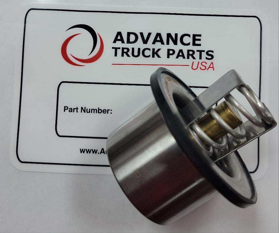 Advance Truck Parts USA 3335550 thermostat for Cummins ISX and QSX engines, displaying an angled studio view of the stainless steel valve and seal positioned in front of a branded box label