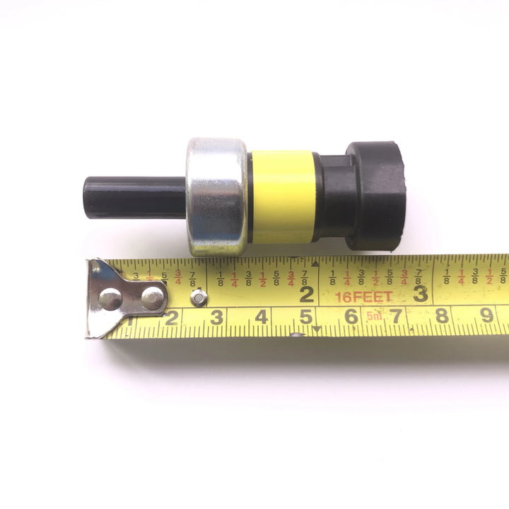 Advance Truck Parts USA pressure switch for Navistar International shown alongside a tape measure to demonstrate overall length and physical dimensions 