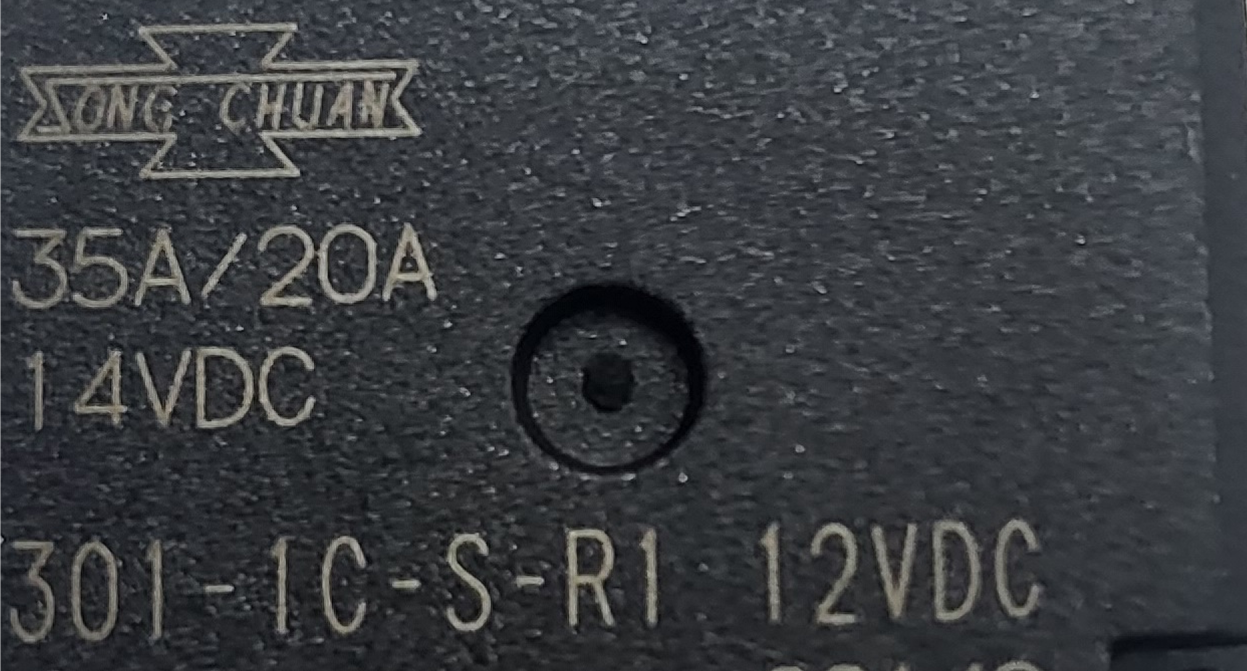 Studio close-up macro perspective highlighting the printed factory specifications, 35A/20A amperage ratings, coil voltage, and manufacturer logo on the top of the black Song Chuan micro automotive relay